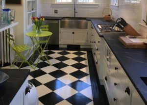 Oiled Vermont Soapstone countertops are the perfect compliment to this stylish black and white kitchen.