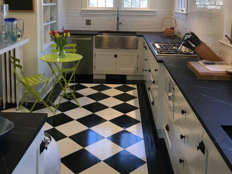 Oiled Vermont Soapstone countertops are the perfect compliment to this stylish black and white kitchen.