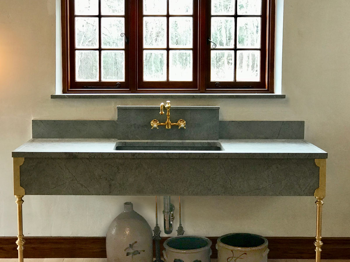 Stunning extra-wide Vermont Soapstone sink with gold accents is the focalpoint of the room.