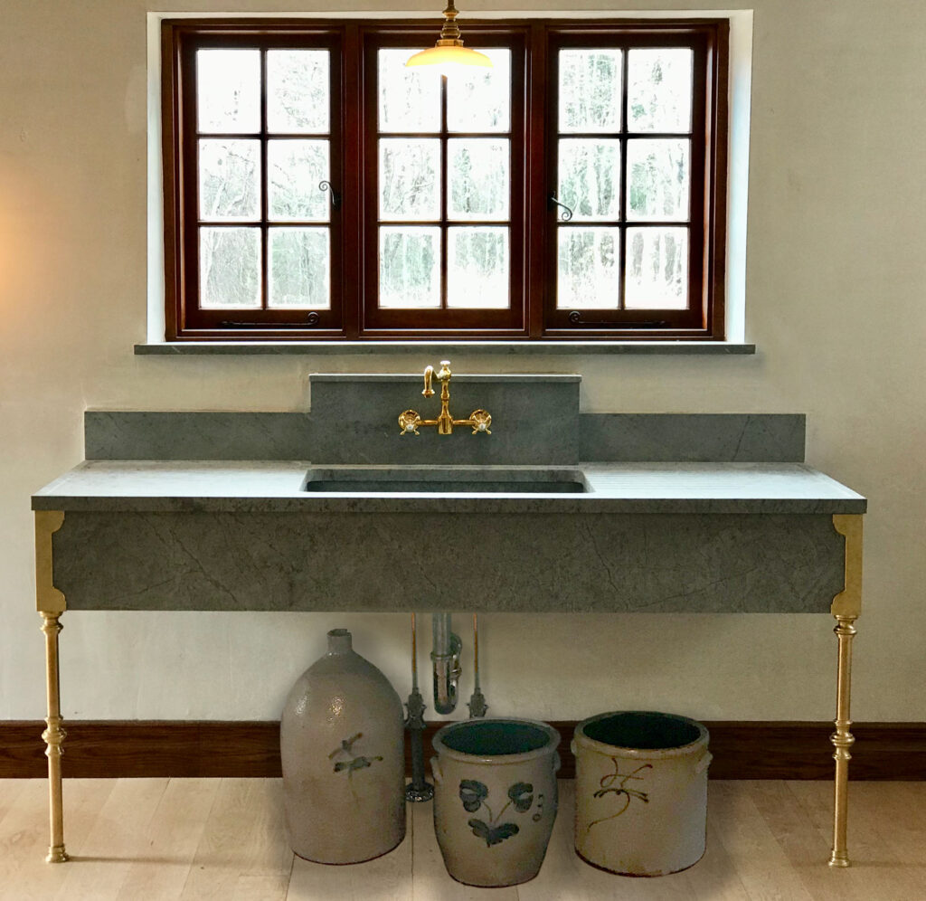 Stunning extra-wide Vermont Soapstone sink with gold accents is the focalpoint of the room.