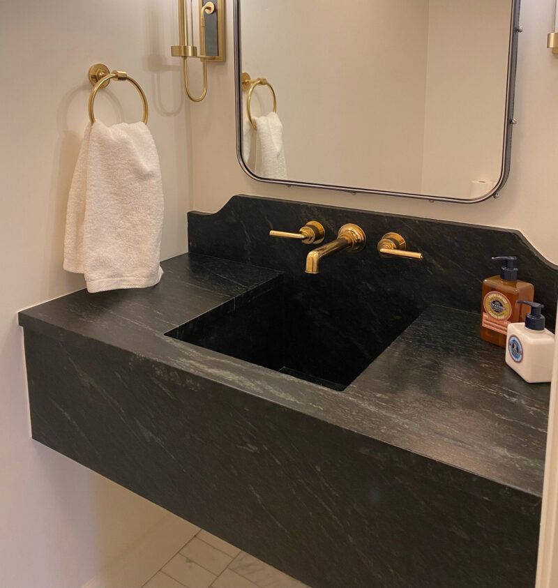 A custom Vermont Soapstone wall-mounted sink makes the most of a tight nook.