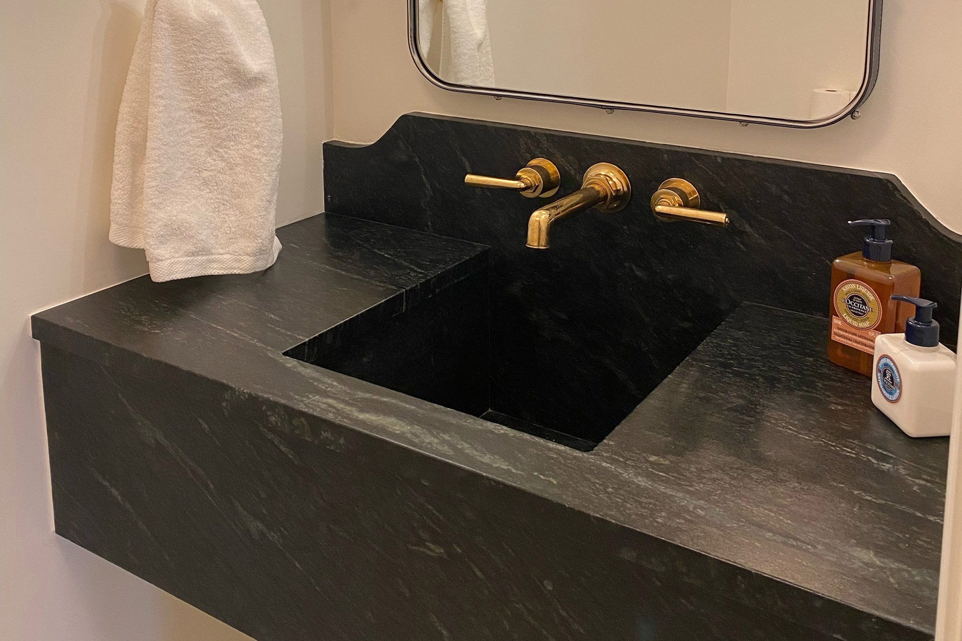 A custom Vermont Soapstone wall-mounted sink makes the most of a tight nook.